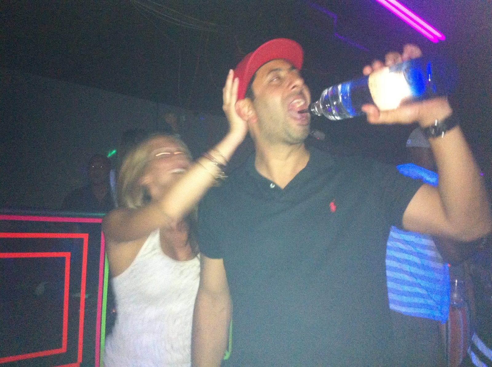 A bottle raised during a loud nightlife celebration