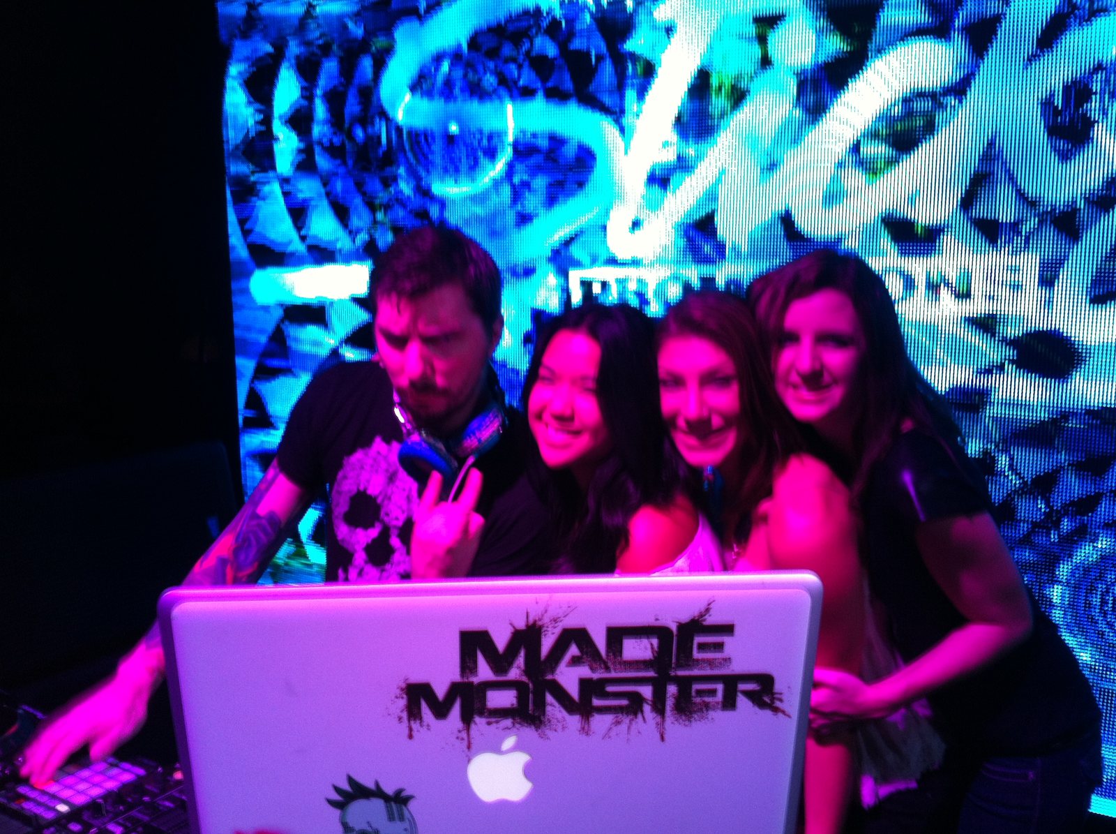 A DJ working the booth beneath electric blue light