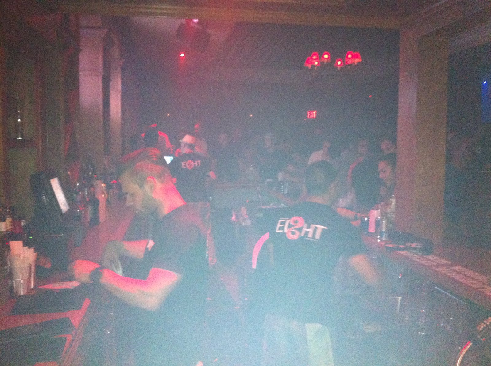 A red-lit dance floor packed with people