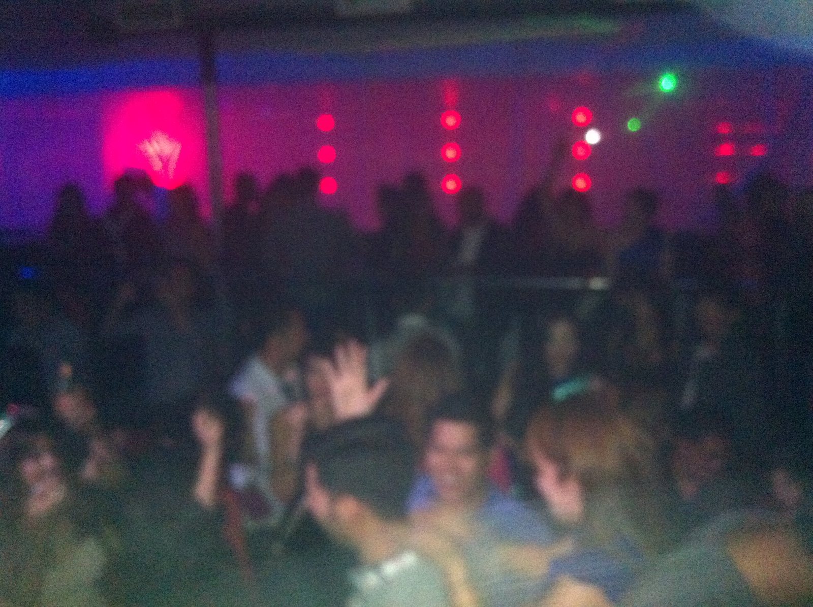 A packed crowd illuminated by red and blue club light