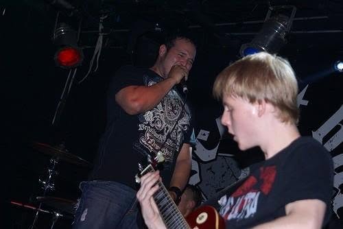 Cixx performing beside a guitarist with Paradigm Grey